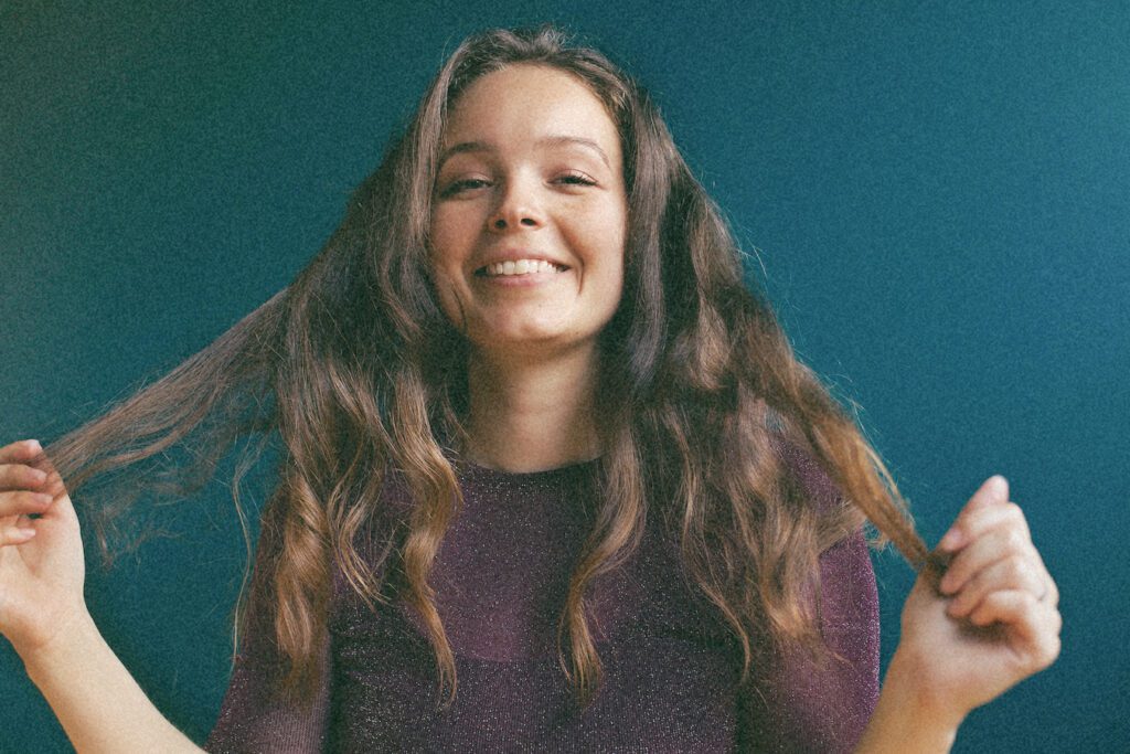 Smiling Zenia Radoor, who is a perfectionist, holding her hair